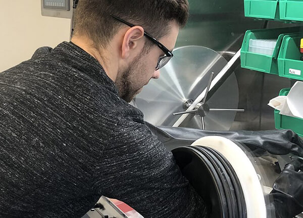 A student using a fabrication machine in a lab.